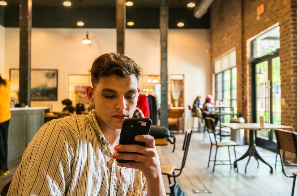 Young man using his smartphone in a café